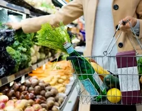 Someone filling a Basket of groceries